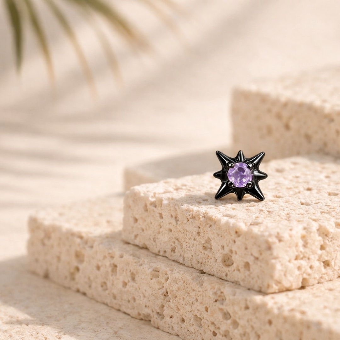 Nose stud en titane noir en forme d'étoile à huit branches serti d'un zircon violet, posé sur une pierre claire