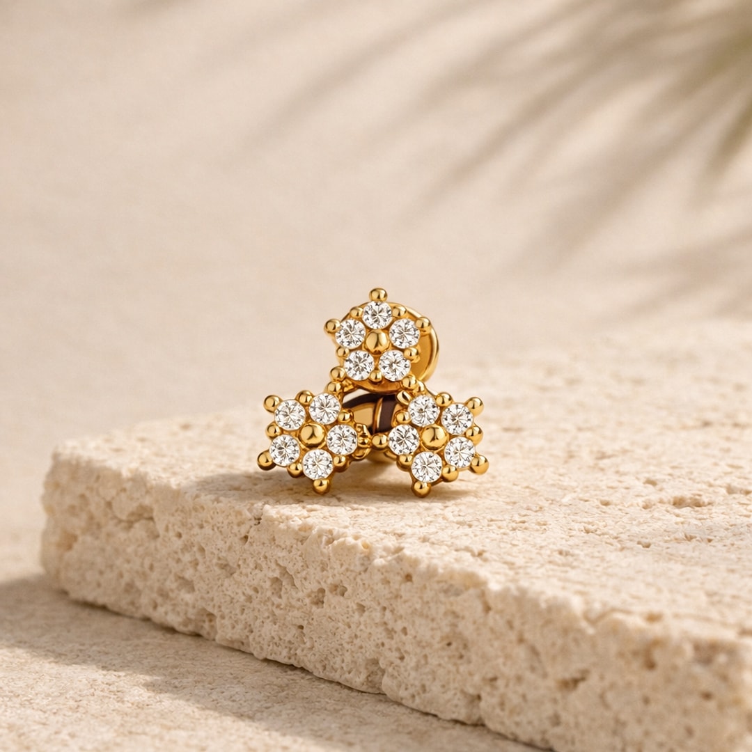 Labret doré en acier avec trois fleurs serties de zircons blancs, posé sur une pierre claire