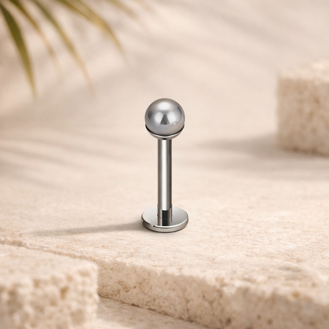 Stud flat back en titane argenté avec fausse perle ronde de 4 mm, posé sur une pierre claire