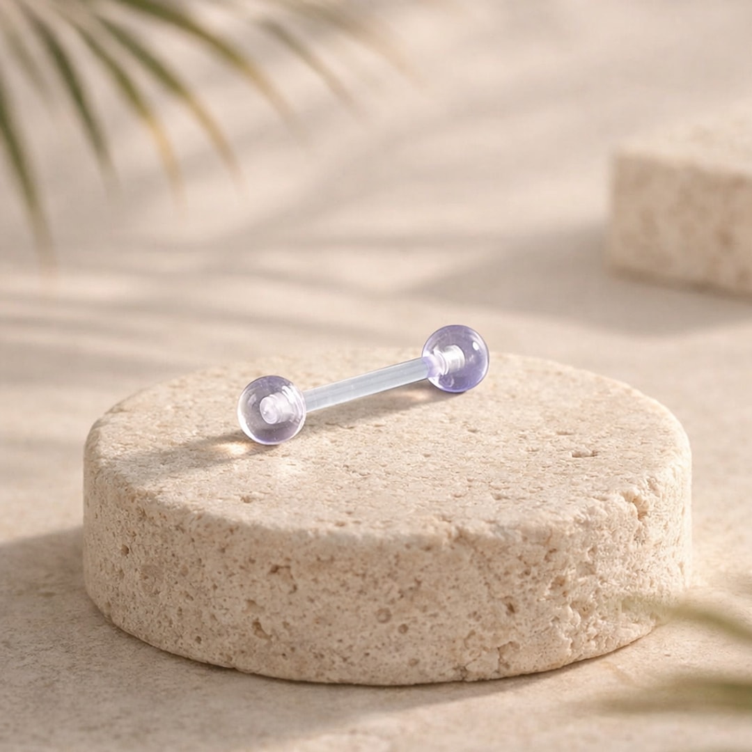 Barre droite en acrylique transparent à boules violettes translucides posée sur un socle de pierre claire