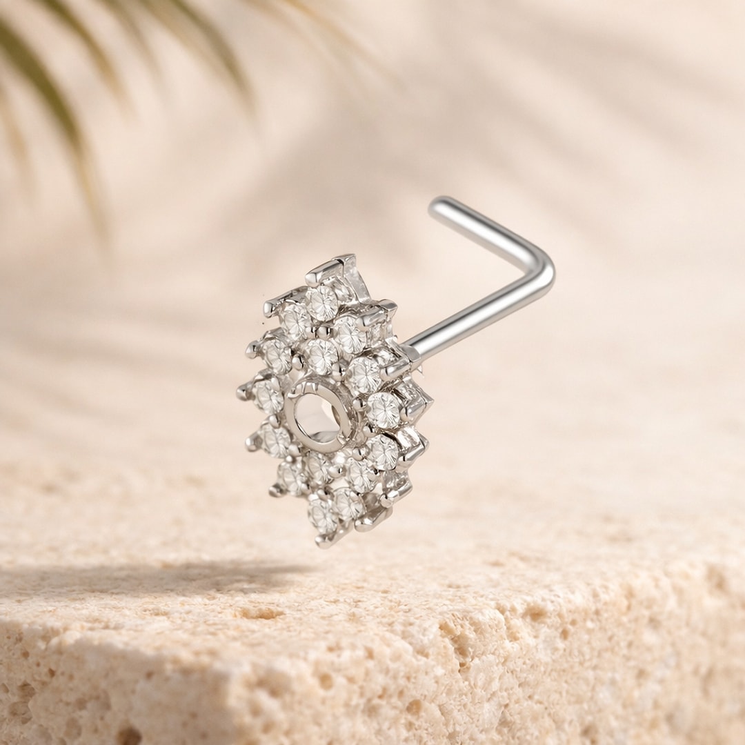 Nose stud en L acier argenté avec rosace de zircons blancs posé sur une pierre claire