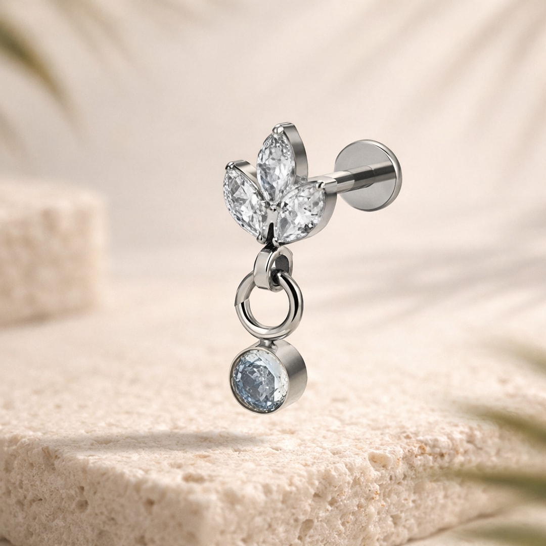 Stud flat back en titane argenté, trois zircons blancs en pétales et pampille ronde sertie, sur pierre claire