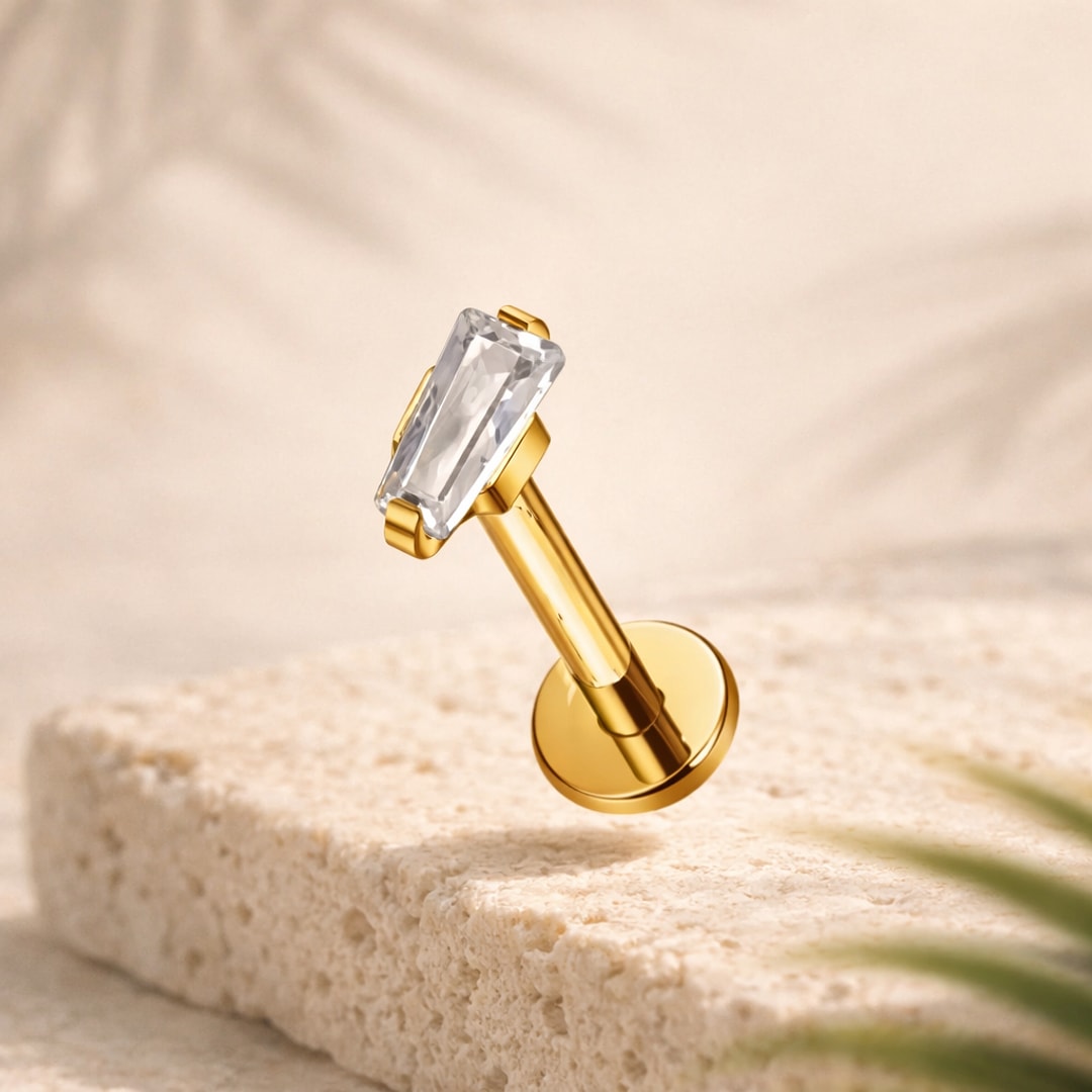 Stud flat back en titane doré avec zircon rectangulaire taille baguette serti griffes, posé sur pierre claire