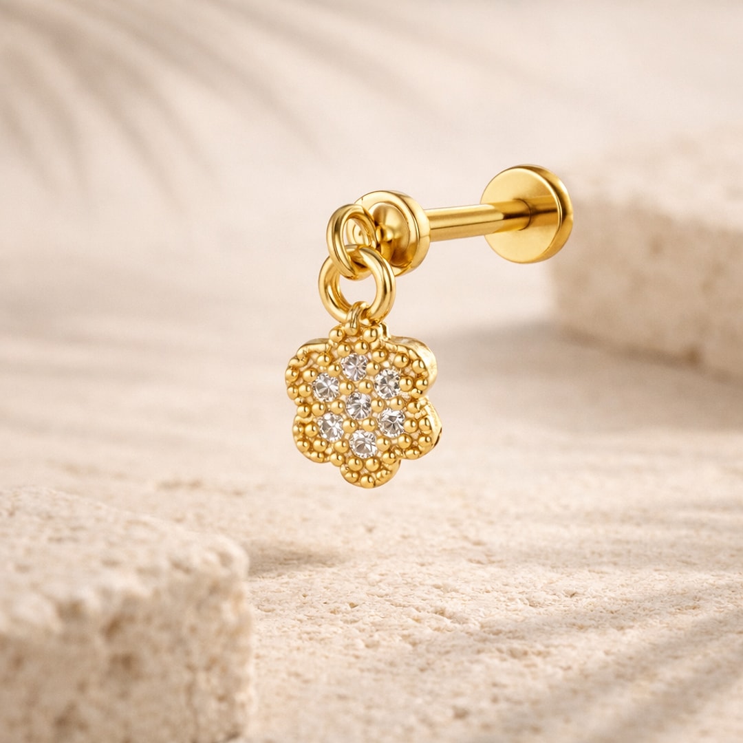 Stud flat back avec pendentif fleur pavé de cristaux, tige à visser, posé sur une pierre claire
