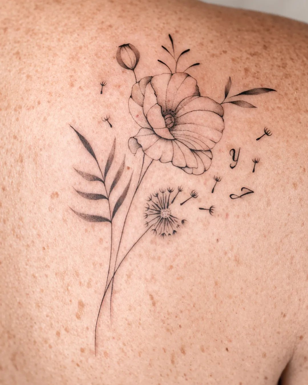 Tatouage femme fleur et pissenlit en fine line sur l’omoplate