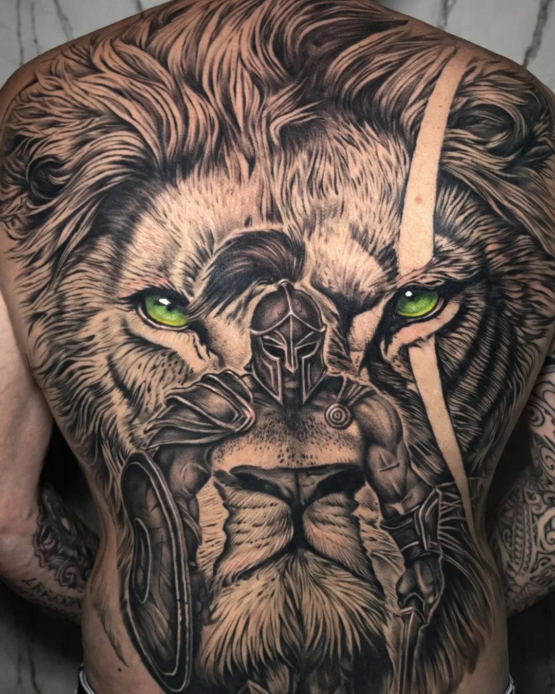 Grand tatouage lion et gladiateur réaliste sur tout le dos