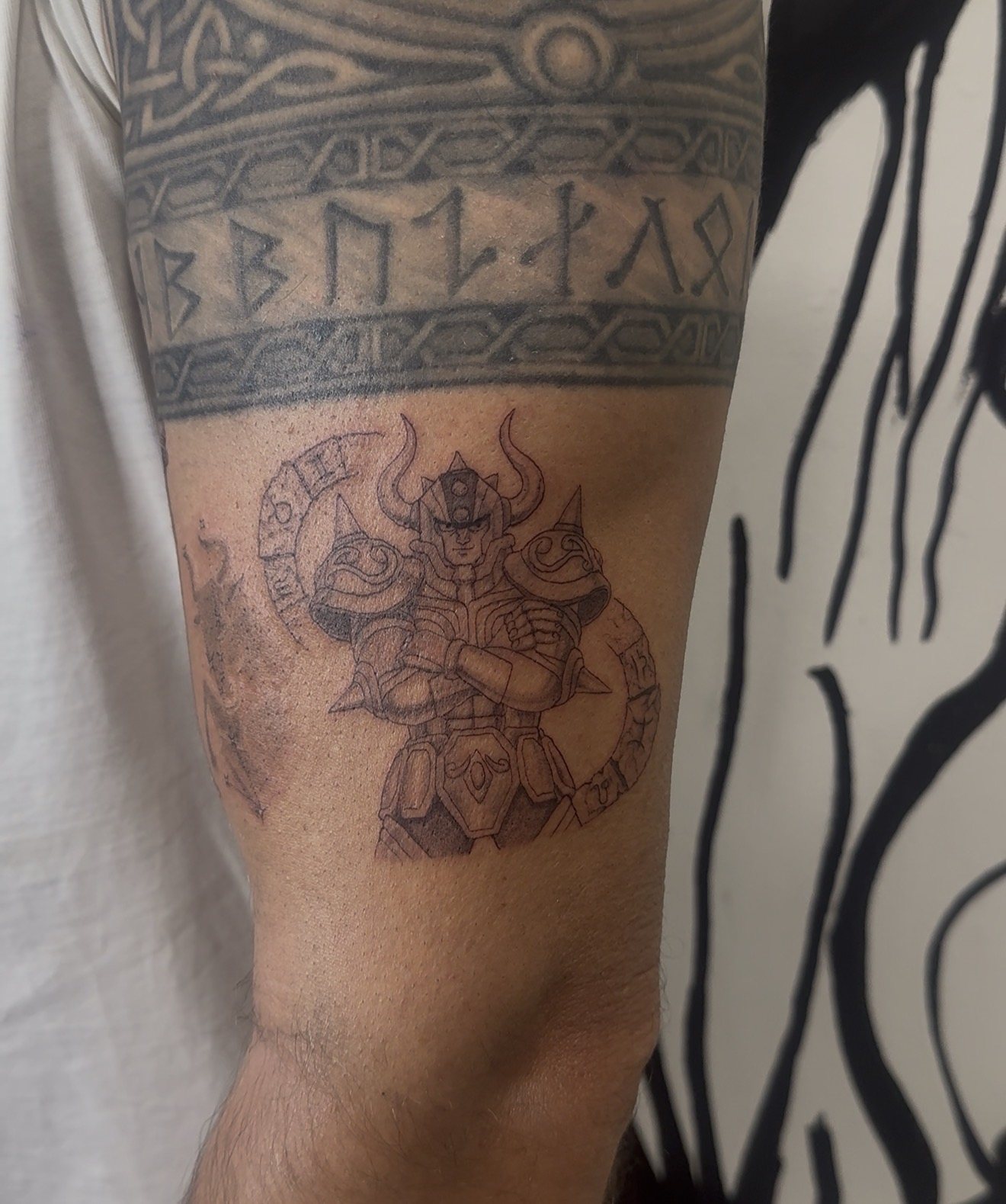 Tatouage guerrier viking et frise de runes sur le bras