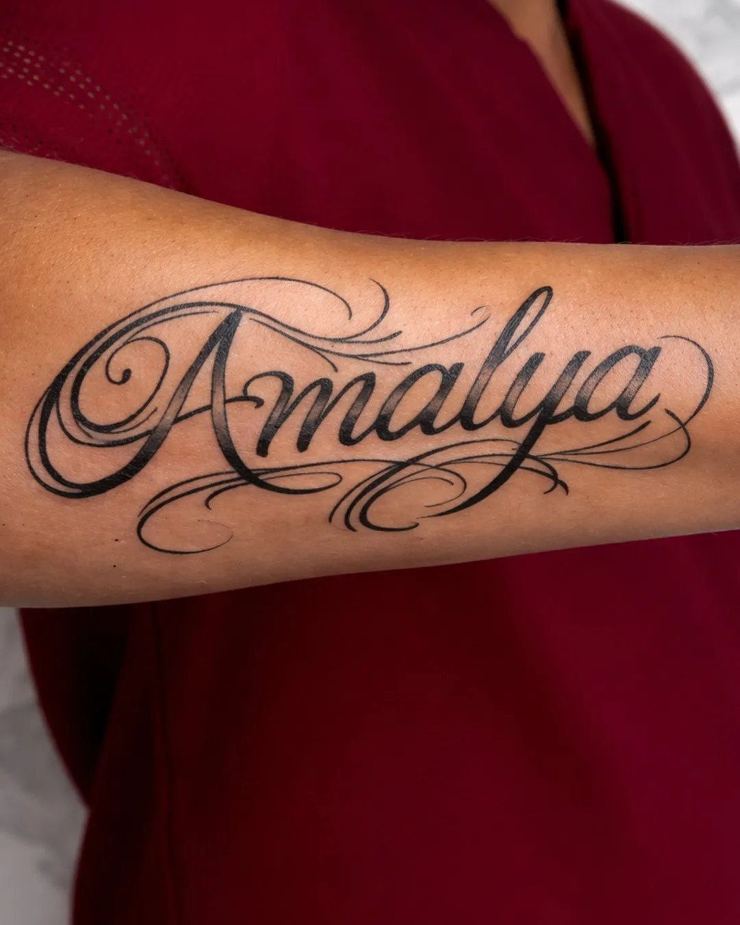 Tatouage lettrage calligraphié du prénom Amalya sur l’avant-bras