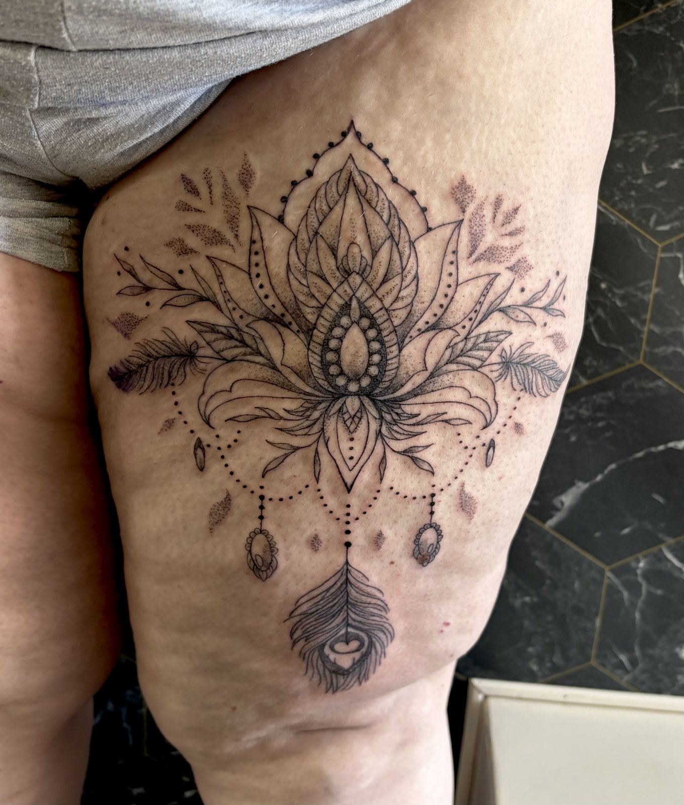 Tatouage lotus ornemental entouré de fleurs sur la cuisse