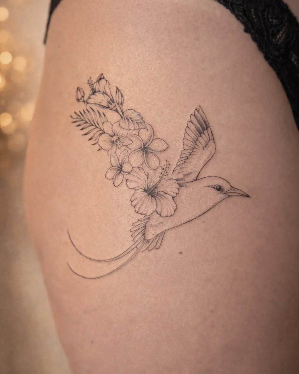 Tatouage paille-en-queue avec des fleurs tropicales sur l’épaule