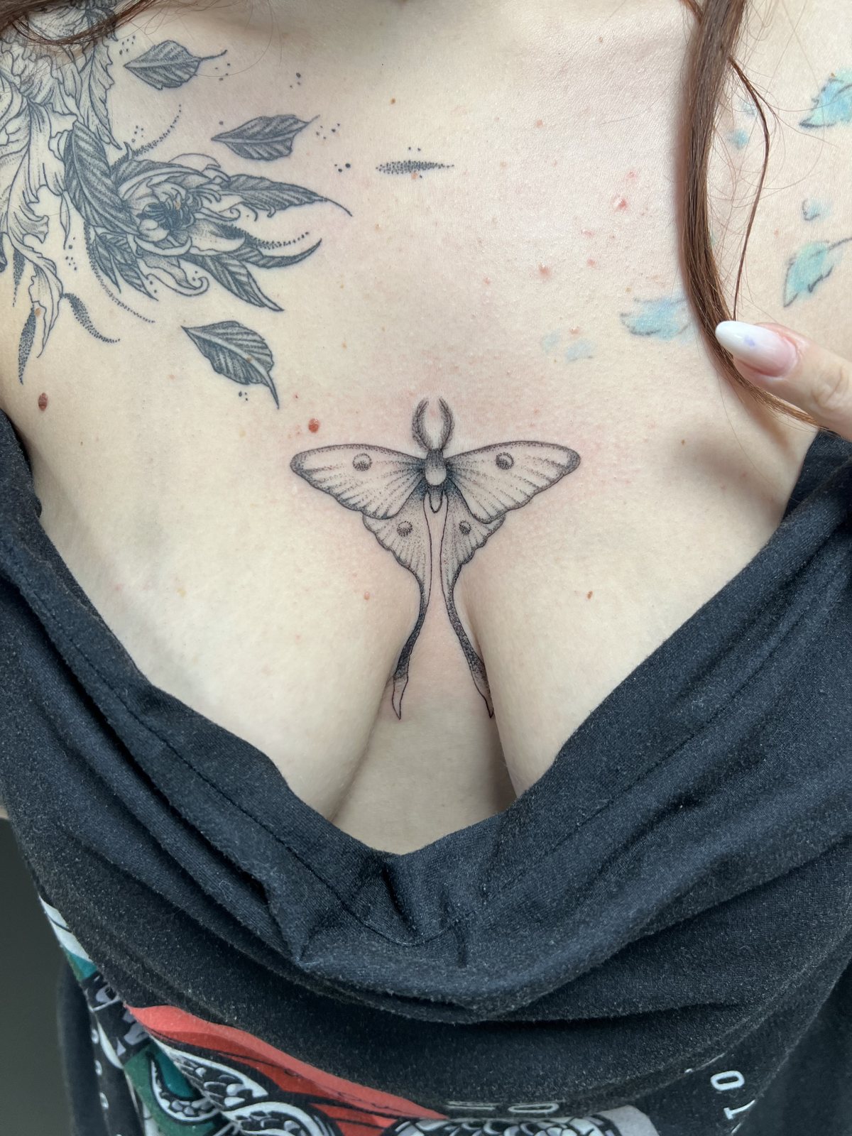 Tatouage papillon de nuit en fine line sur la poitrine