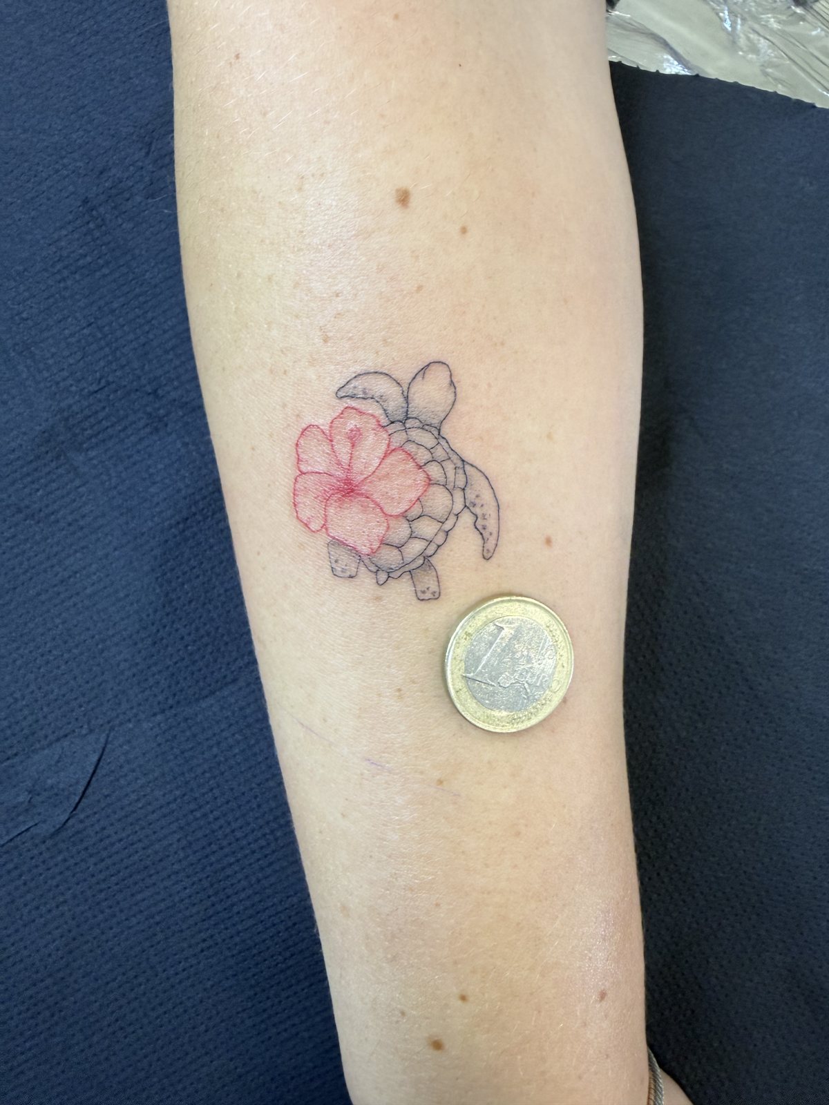 Petite fleur d’hibiscus rose tatouée avec une tortue