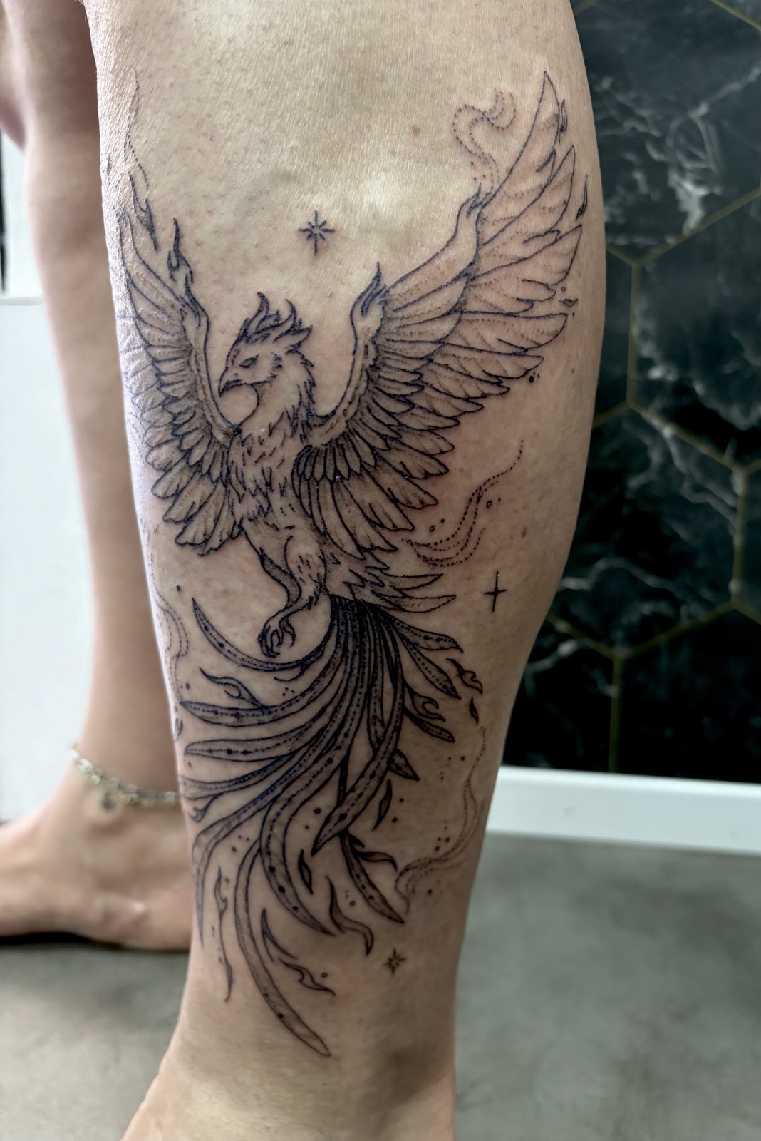 Tatouage phénix en fine line sur le mollet