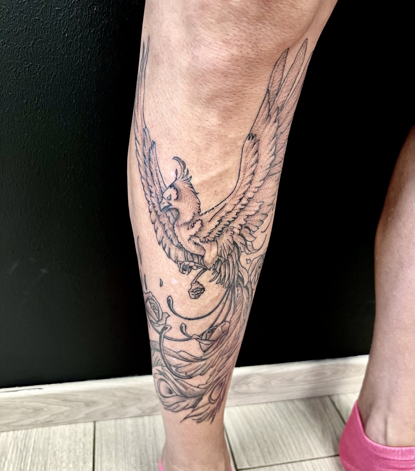 Tatouage phénix et fleurs sur le mollet