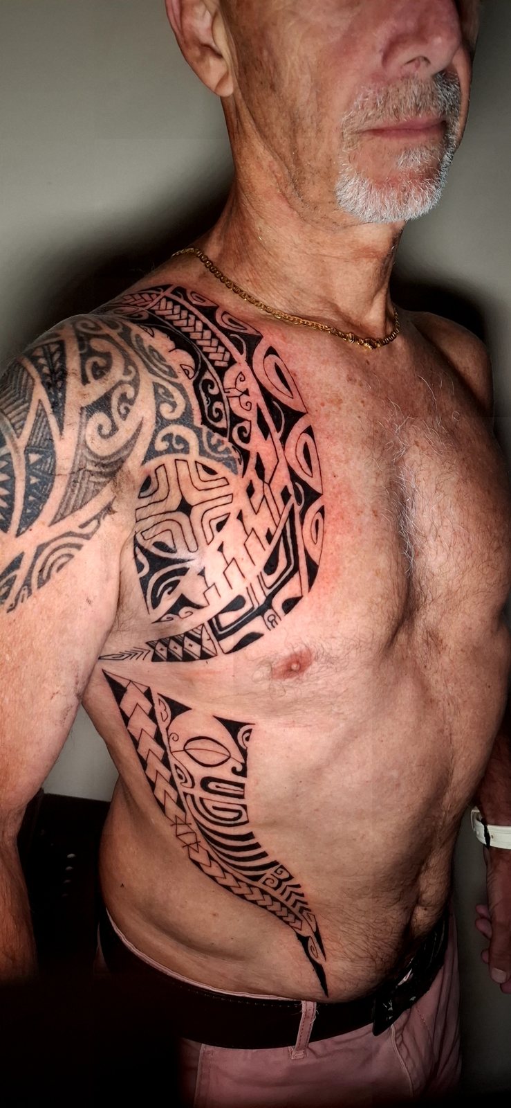 Tatouage polynésien sur l’épaule et le torse d’un homme
