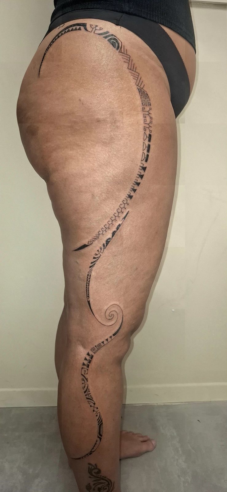 Tatouage polynésien sur toute la jambe d’une femme