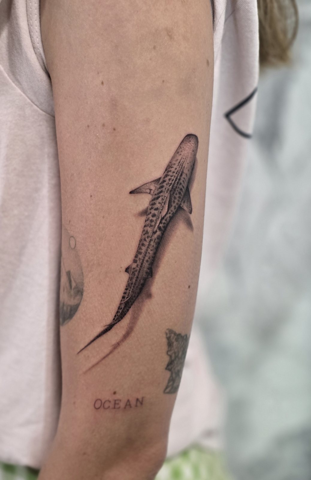 Tatouage requin-baleine avec le mot Ocean sur l’avant-bras