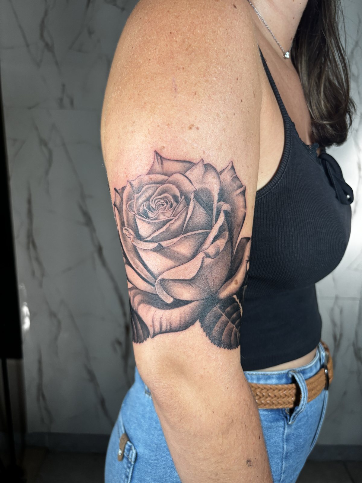 Tatouage rose réaliste réalisé en recouvrement sur le bras