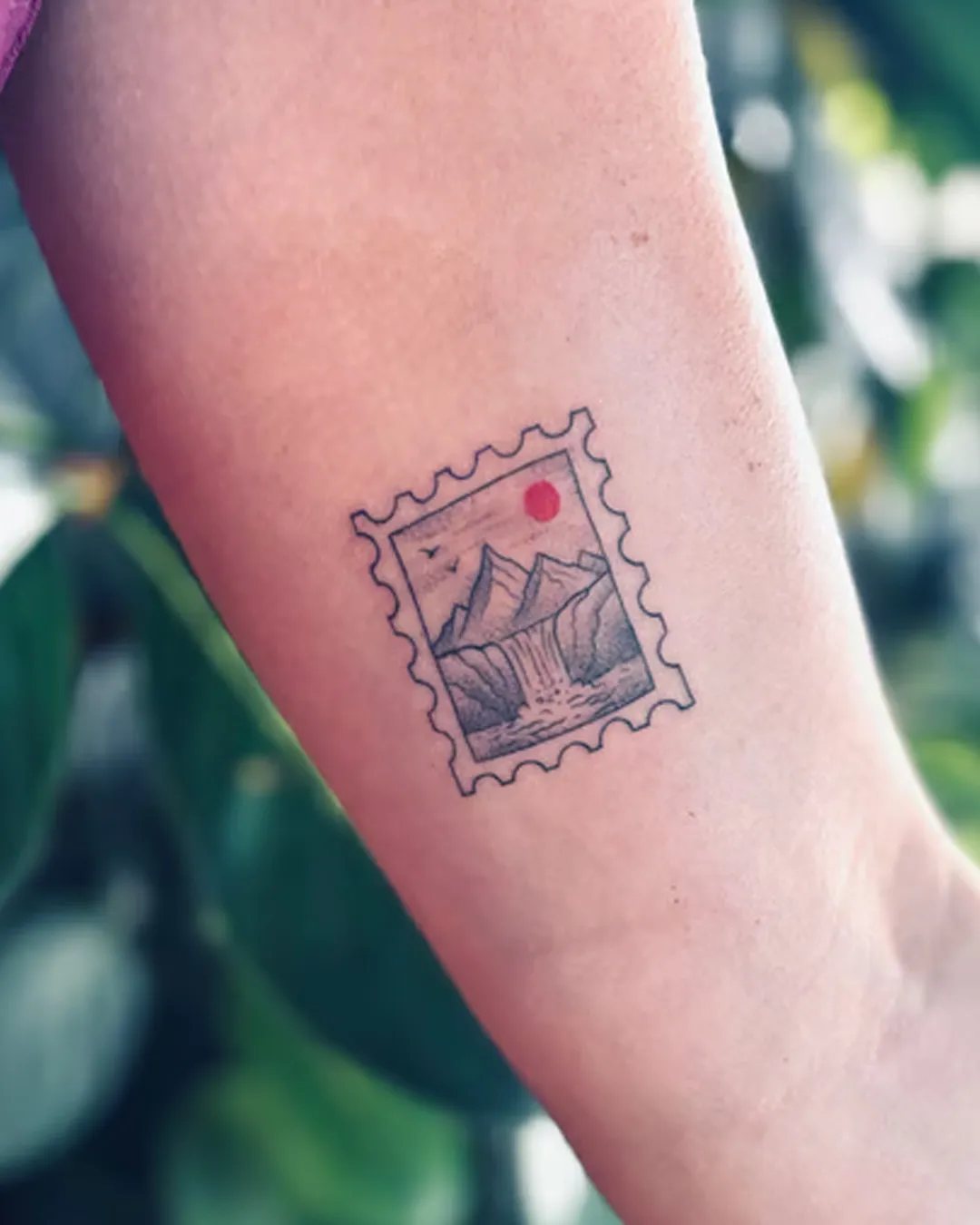Tatouage timbre avec montagnes, cascade et soleil rouge