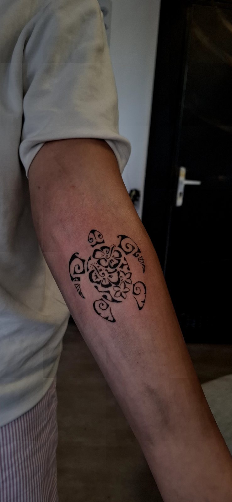 Tortue polynésienne tatouée sur l’arrière du bras